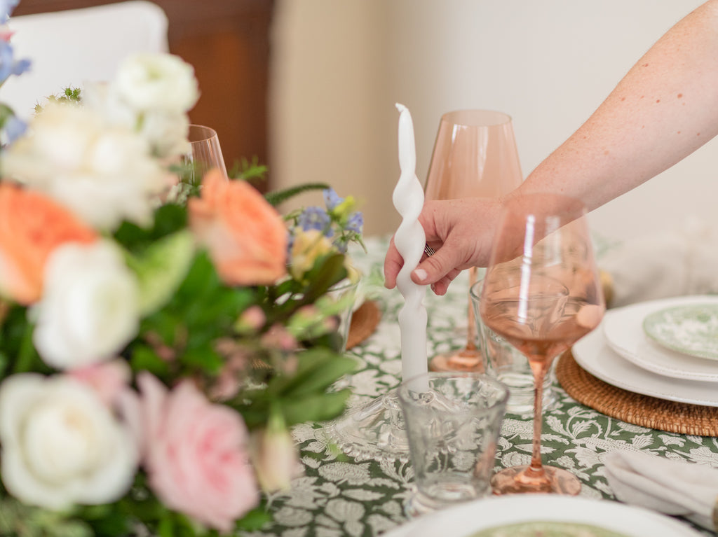 Ryan Harper Designs - Hand Placing White Twisted Candle Down On Green and White Table Setting