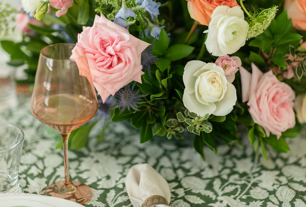 Ryan Harper Designs - Close Up of Rose Colored Wine Glass With Bouquet Centerpiece